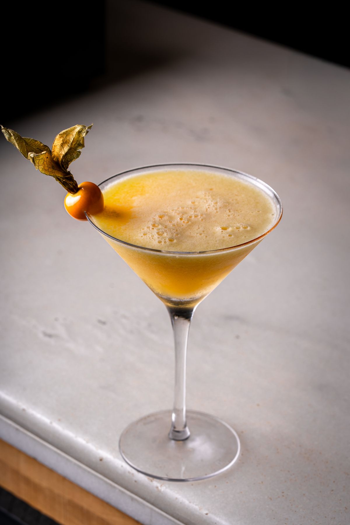 Passion fruit martini on a pale marble surface