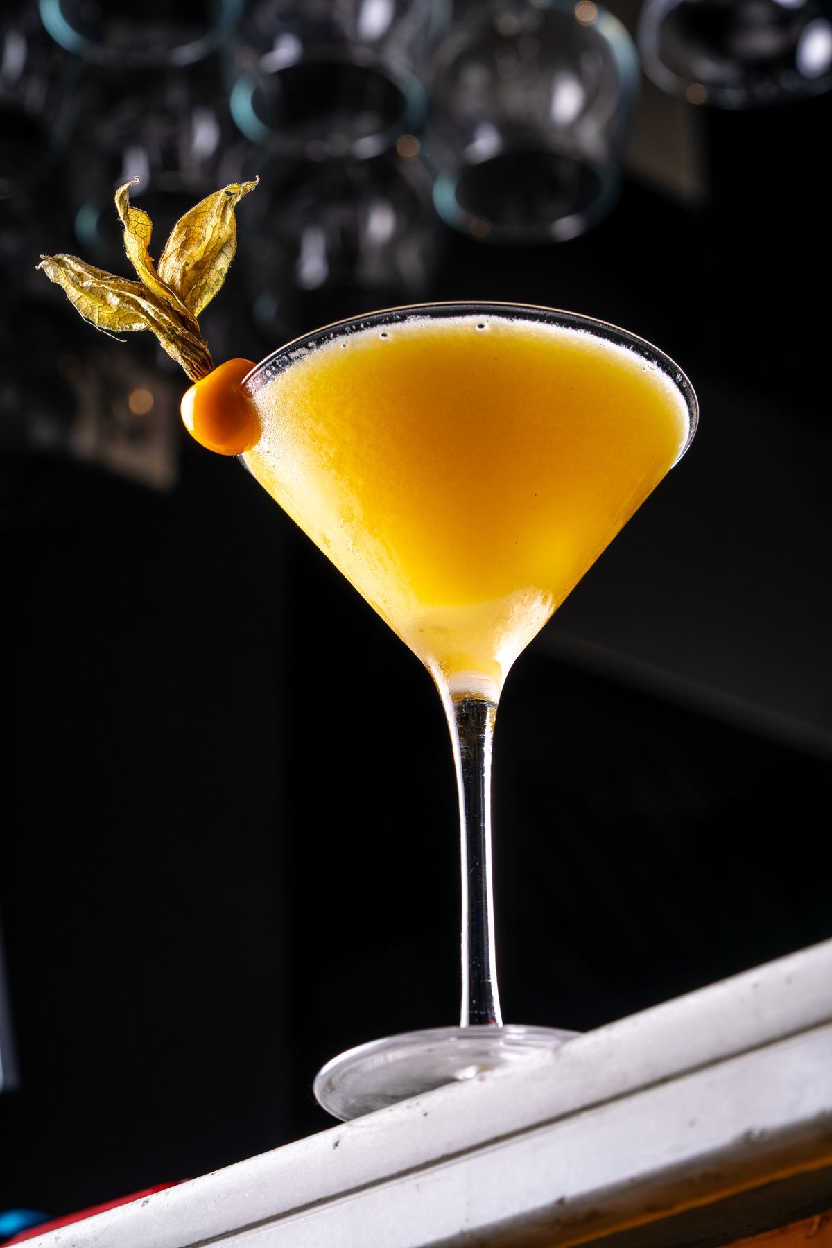 Passion fruit martini garnished with a physalis berry