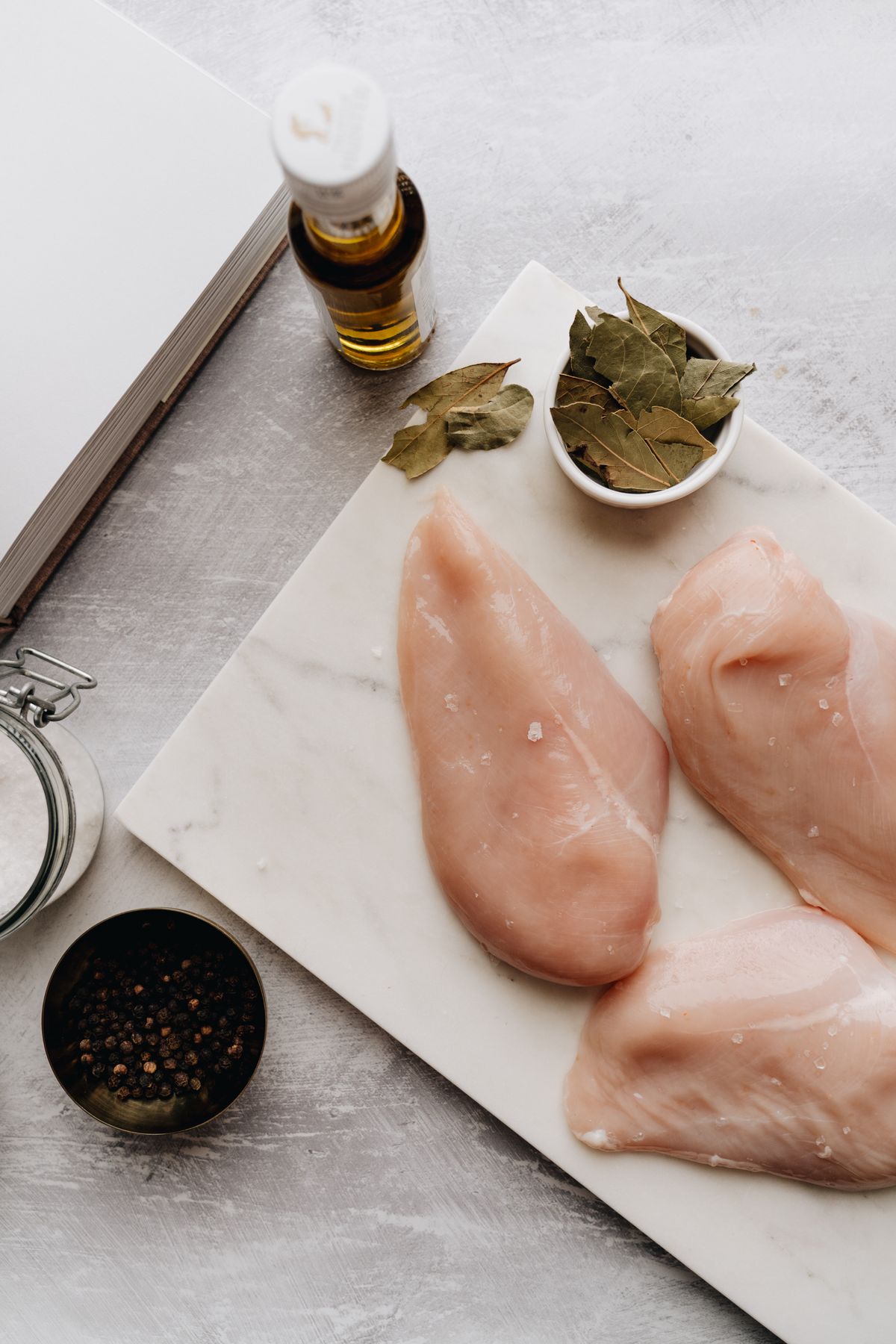 Raw chicken breasts prepared with herbs and olive oil
