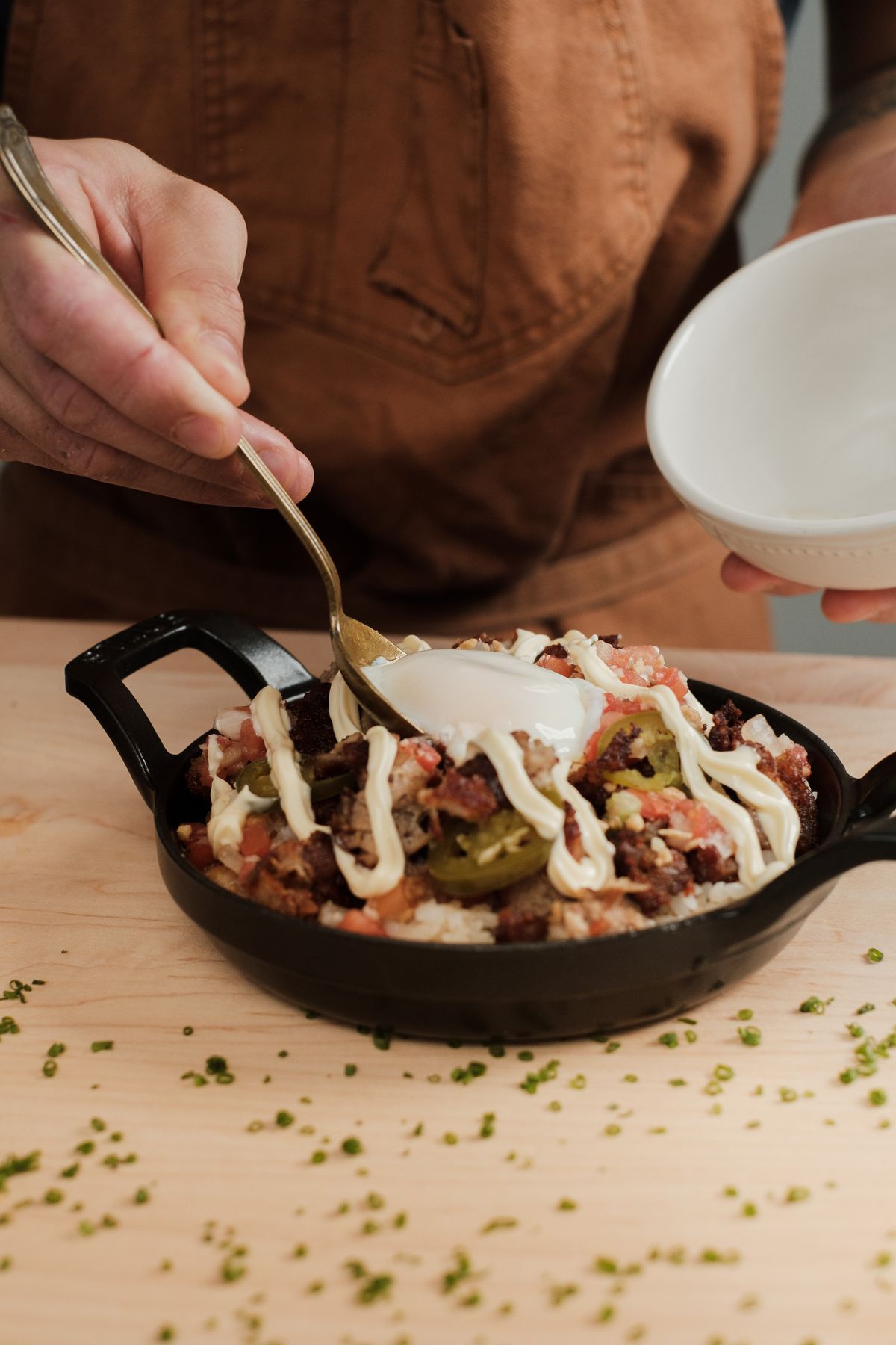 Cook adding sauce to food in a hot pan